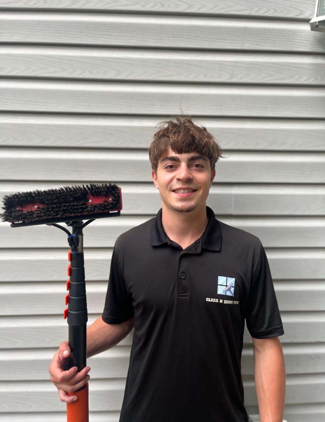Daniel, founder of Glass N Shine HFX, holding a water-fed window cleaning pole